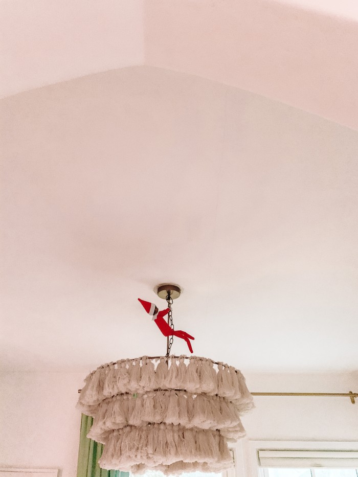 Elf on the Shelf swinging from chandelier