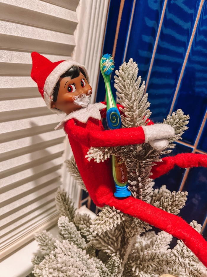 elf brushing his teeth sitting in tree