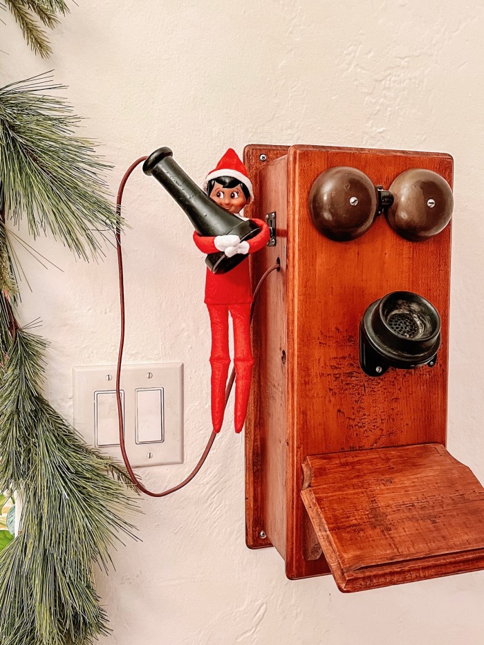 Elf on the Shelf hanging on old phone