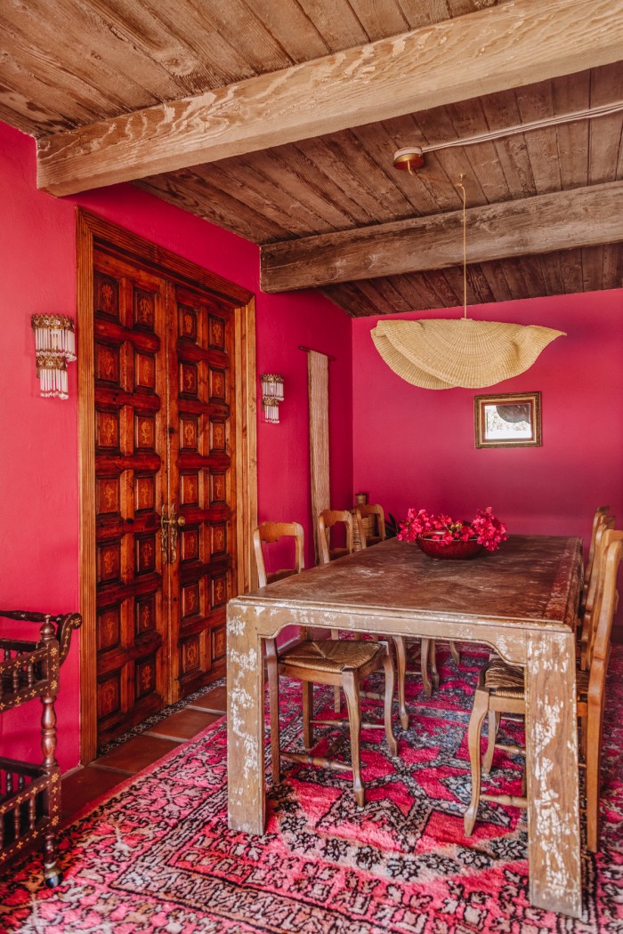 pink dining room with wood table and wood ceilings