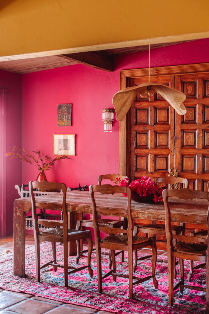 pink dining room with wood table and chairs