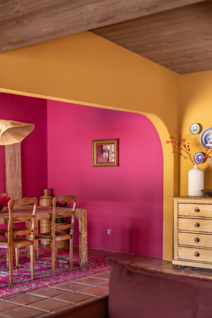 pink dining room through yellow arch