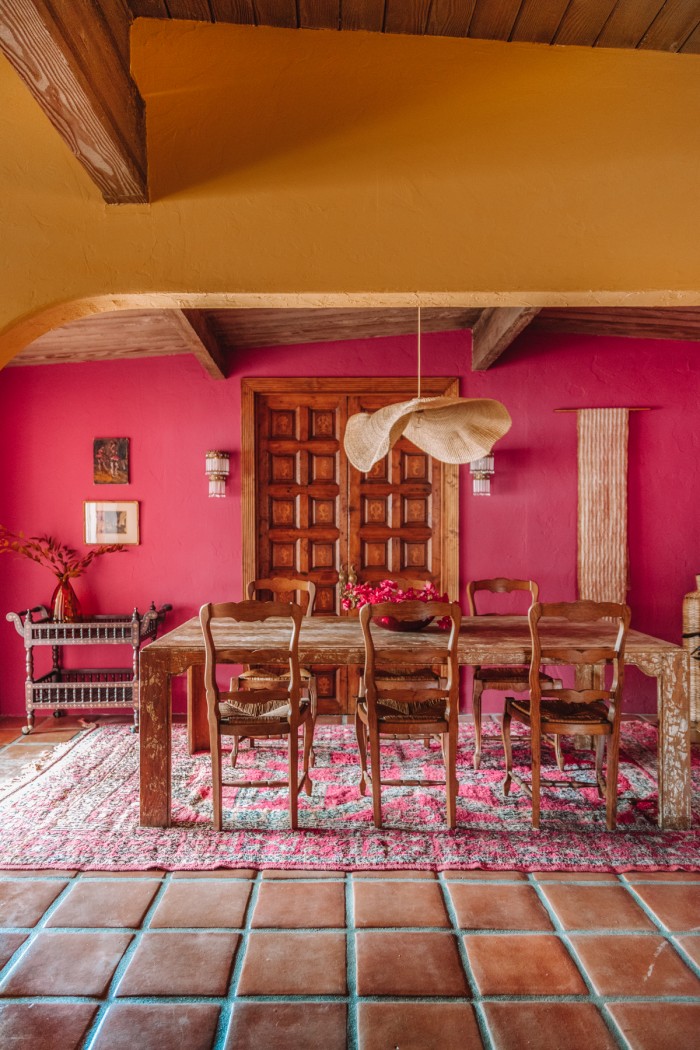 pink dining room behind yellow wall