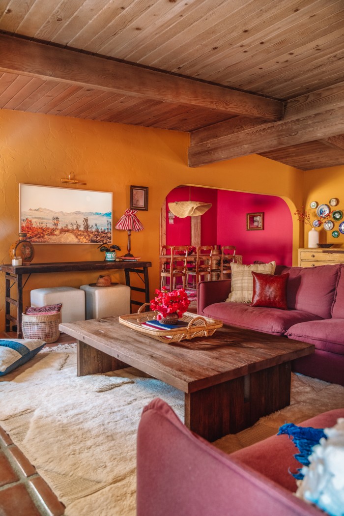 Purple couch and wood coffee table in ochre living room