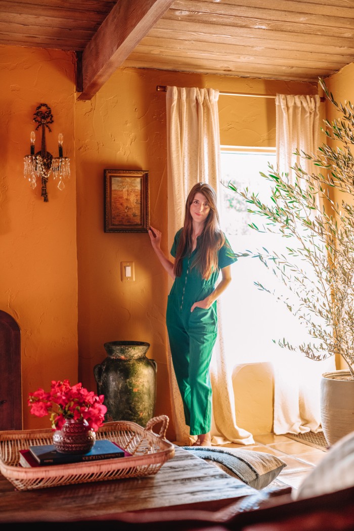 Woman in green standing in ochre living room