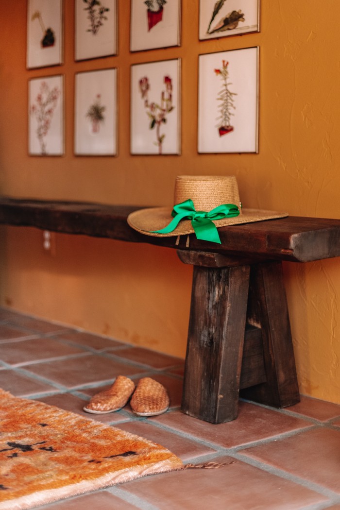 hat on bench under gallery wall