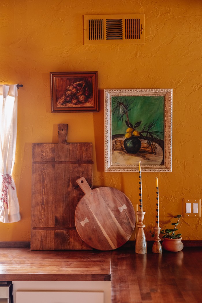 art and cutting boards on wall in yellow kitchen