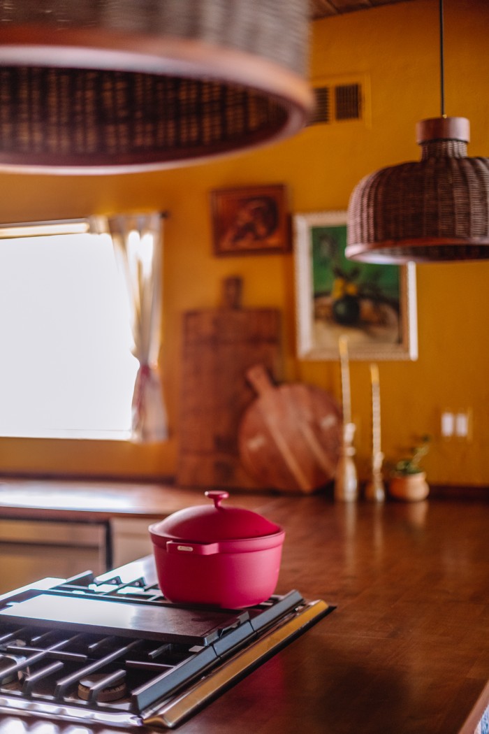 pink pot on stove in yellow kitchen