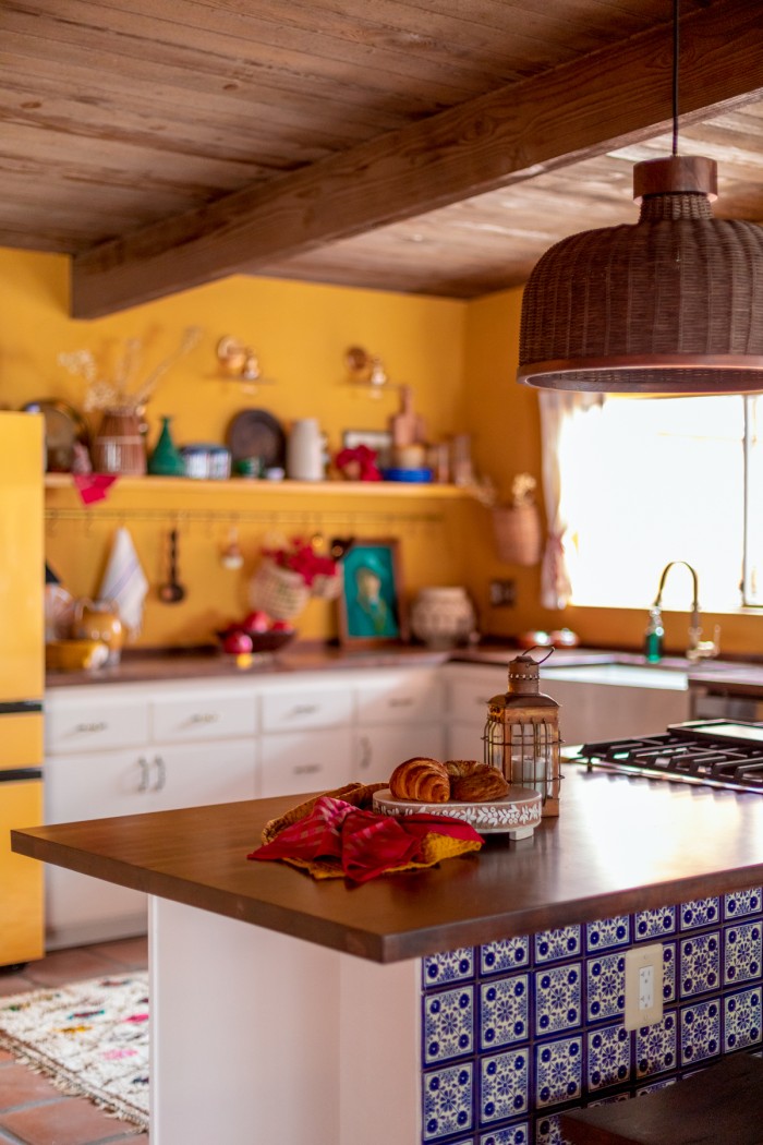 yellow kitchen with dark butcher block counters and wood ceilings