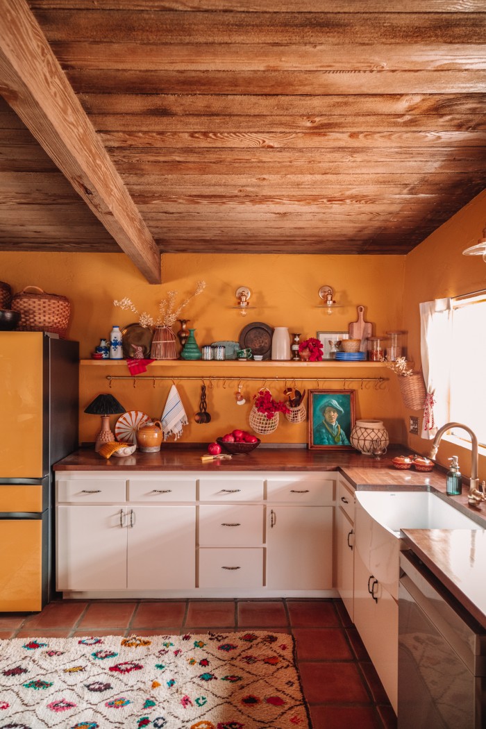 yellow kitchen with cream cabinets and wood ceilings