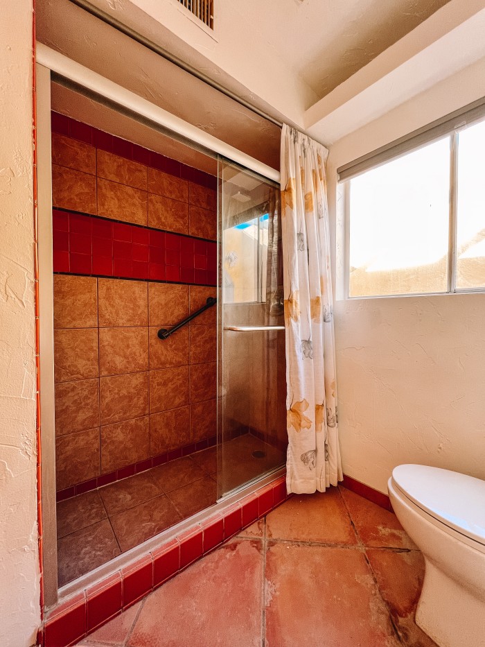 bathroom shower with orange stripe of tile