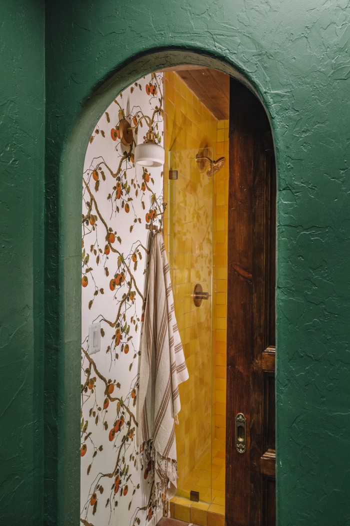 dark green archway with yellow tile behind in shower