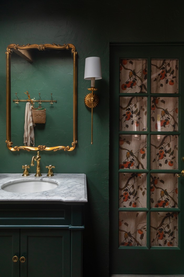 dark green bathroom with door with floral curtain behind it