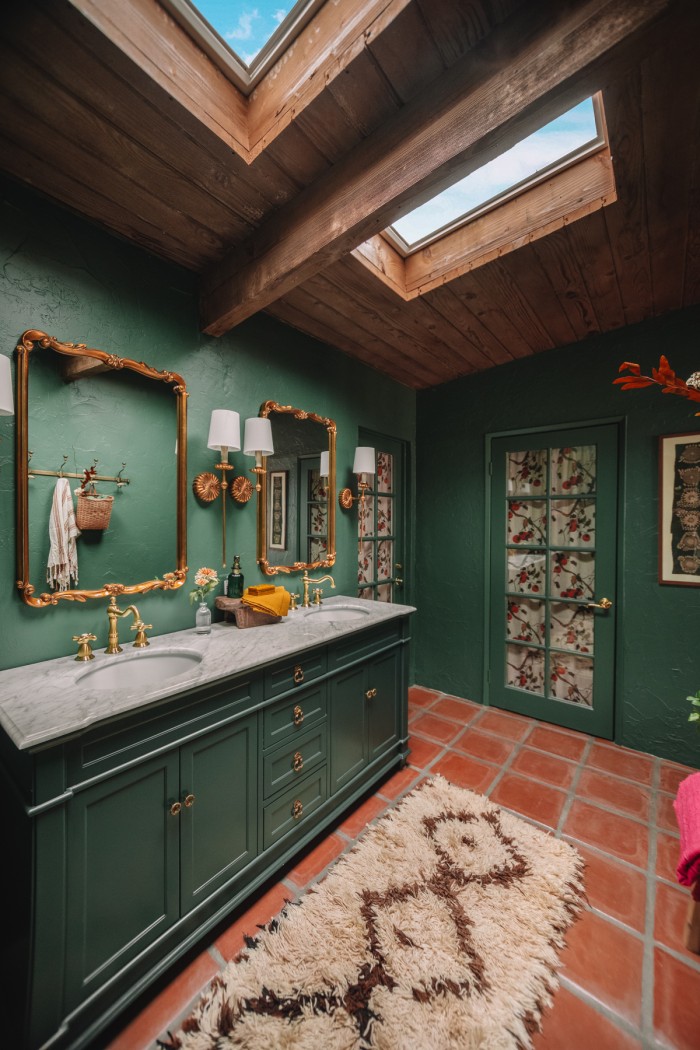 green bathroom with wood ceilings and skylights