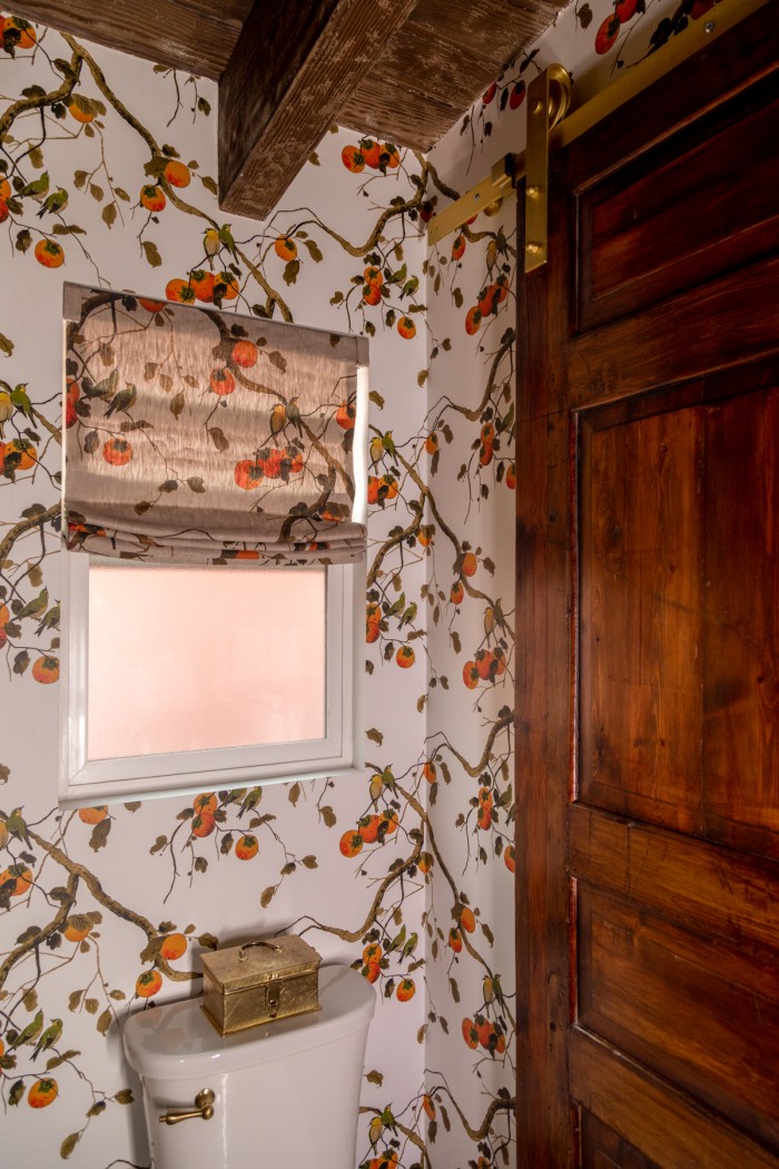 antique door as barn door in floral bathroom