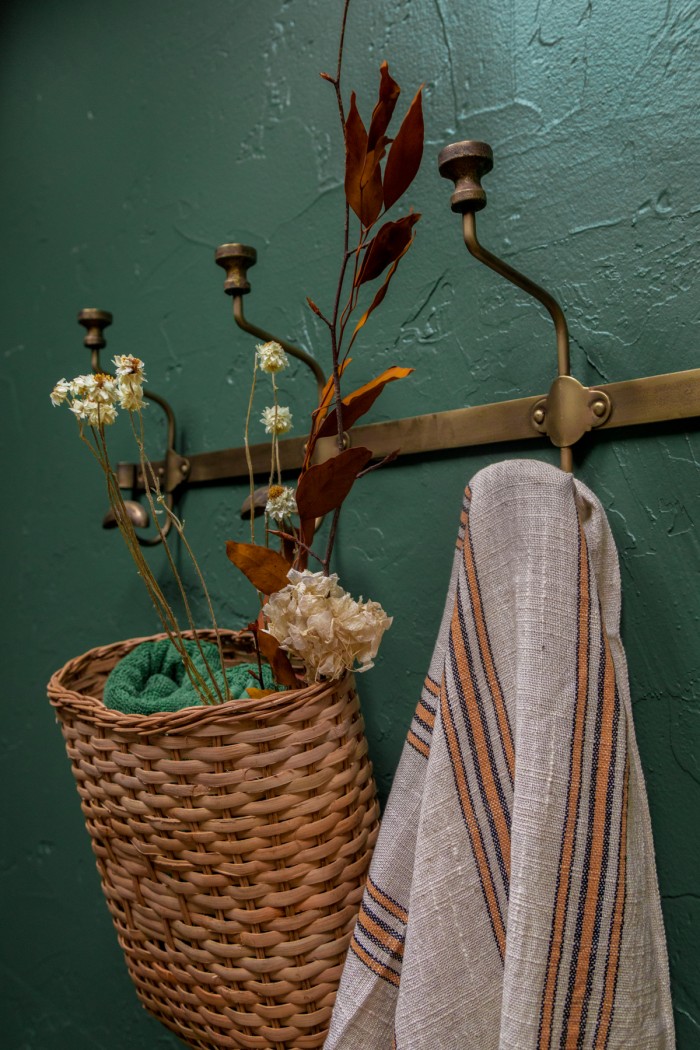 basket hanging on brass coat rack