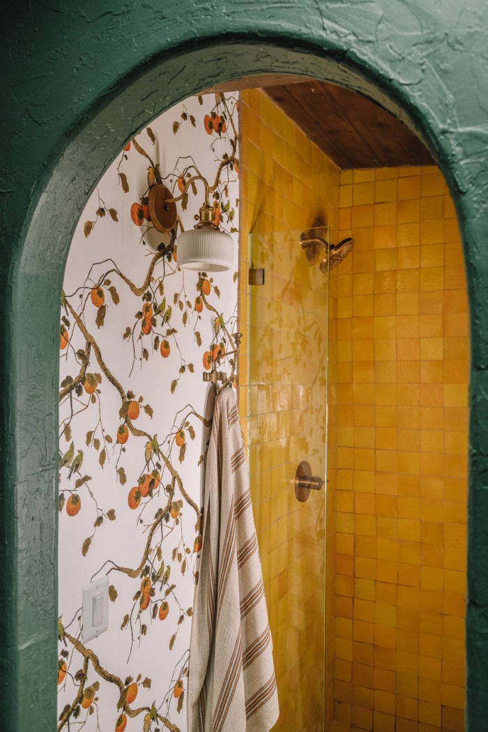 dark green arch with floral wallpaper and yellow tile shower