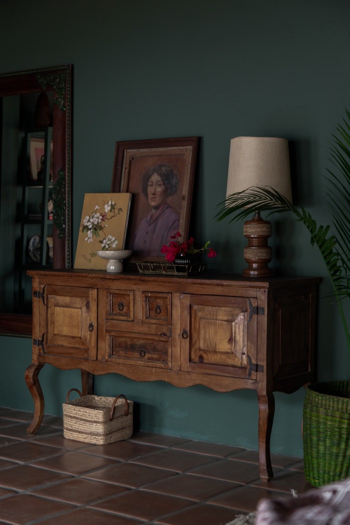 credenza in bedroom with vintage art and lamp on top