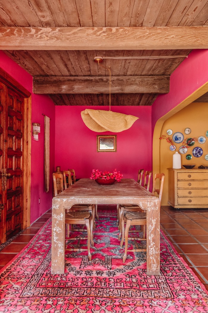 pink dining room with long wood table