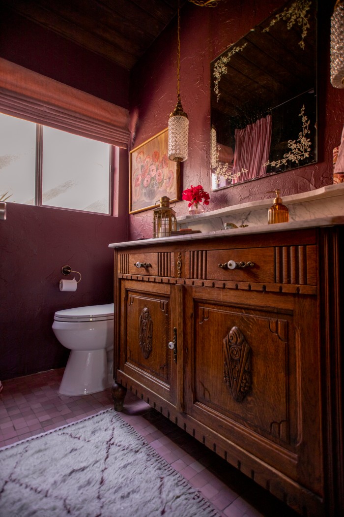 wood vanity with rug in front in purple bathroom