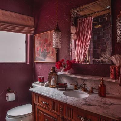 Plum bathroom with antique wood vanity