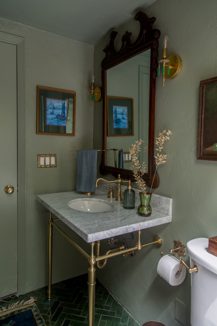 sage green bathroom with wood mirror and marble vanity