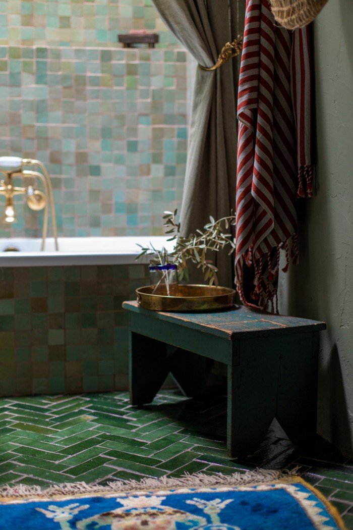 green bathroom with blue rug and stool