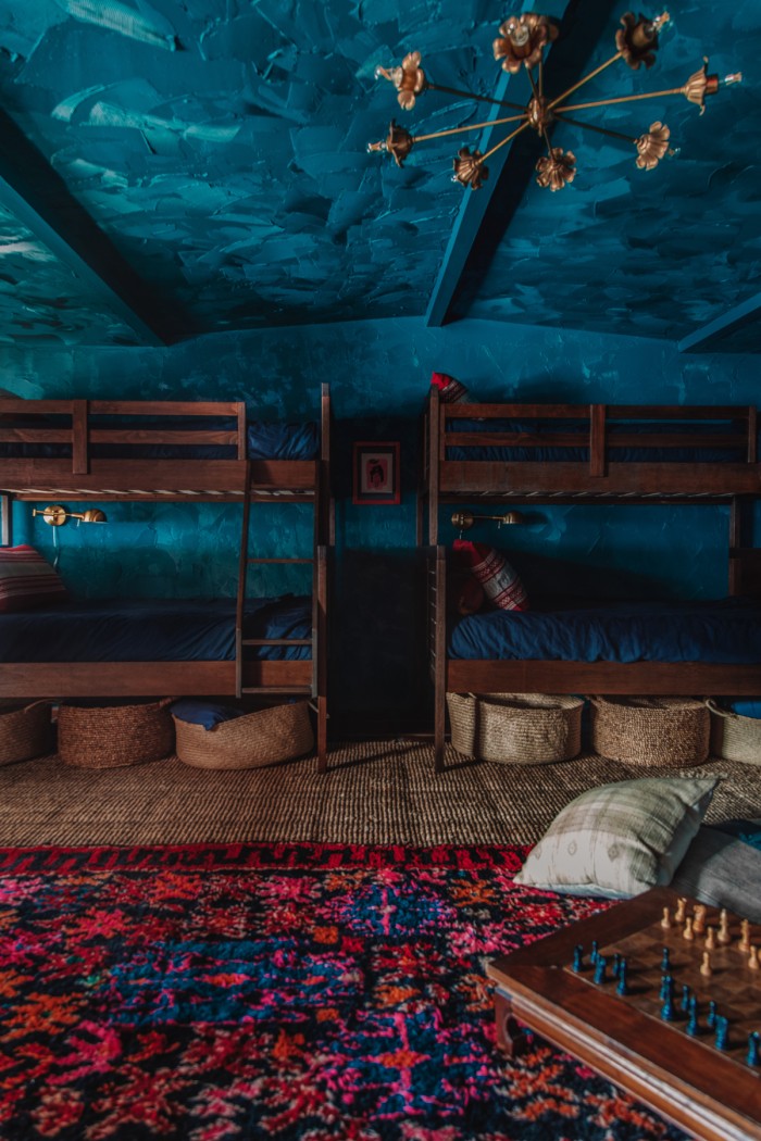 teal room with wood bunk beds and red carpet