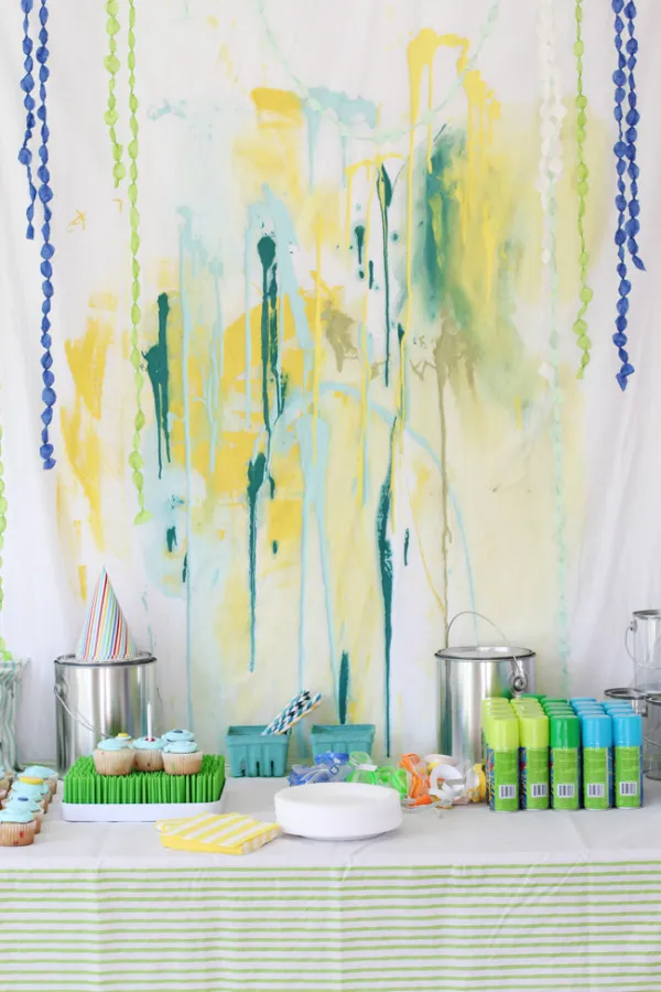 Paint splatter birthday party backdrop and dessert table. 