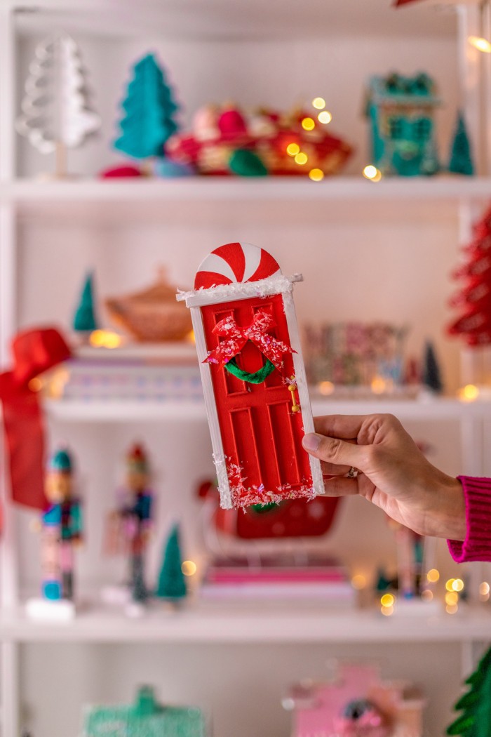 Hand holding the decorated elf door. 