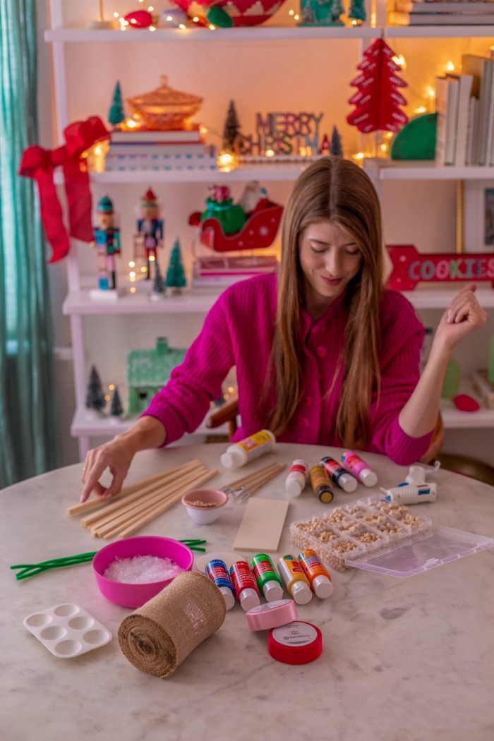Woman sitting at a table with supplies to make an elf door. 