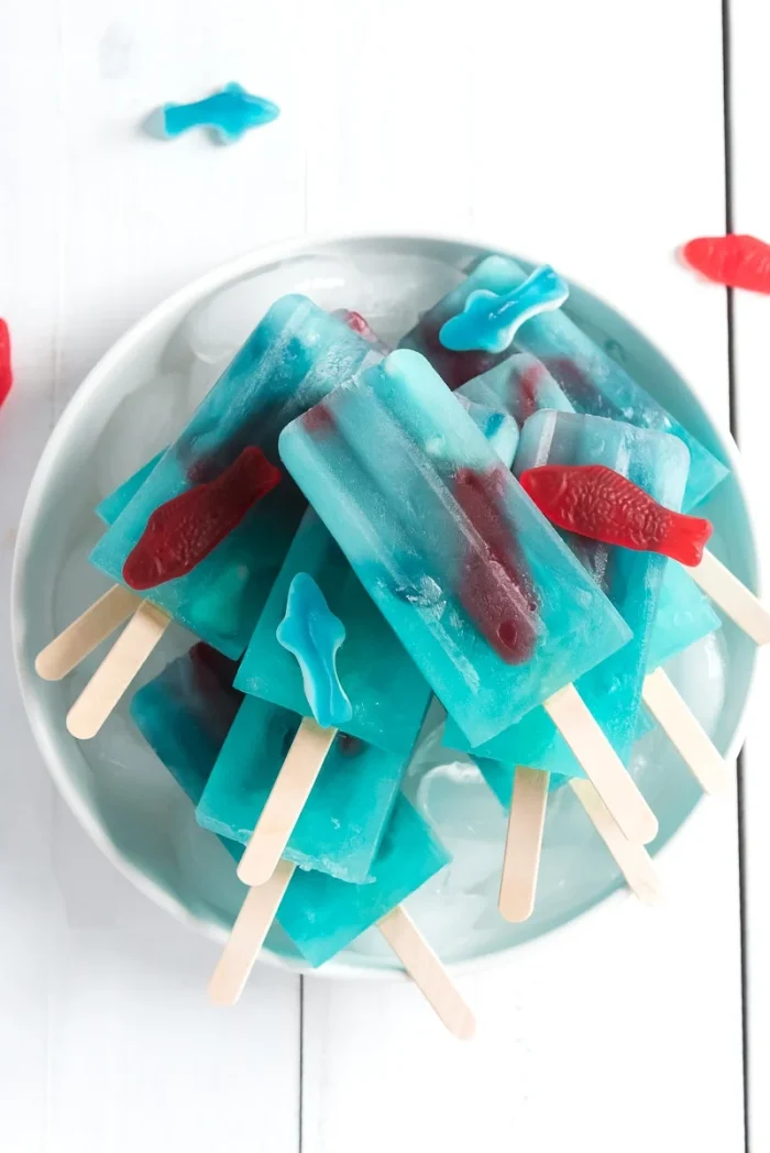Blue lemonade popsicles stacked on a plate.