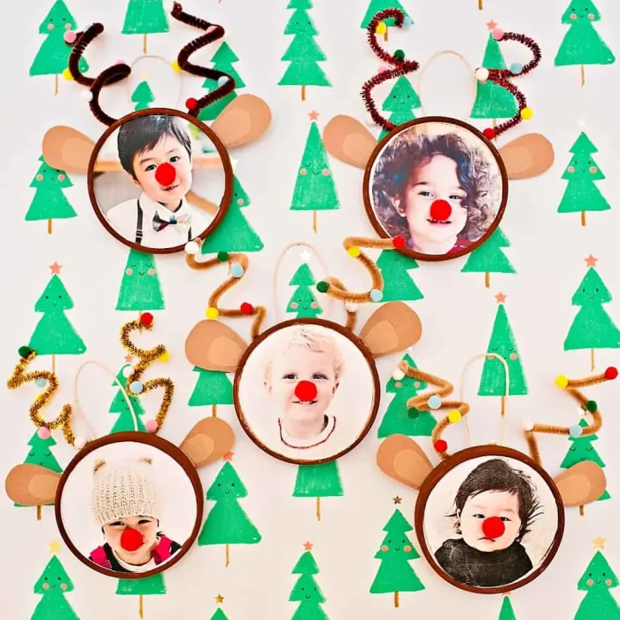 Reindeer ornaments with photos on a background with green trees on it. 