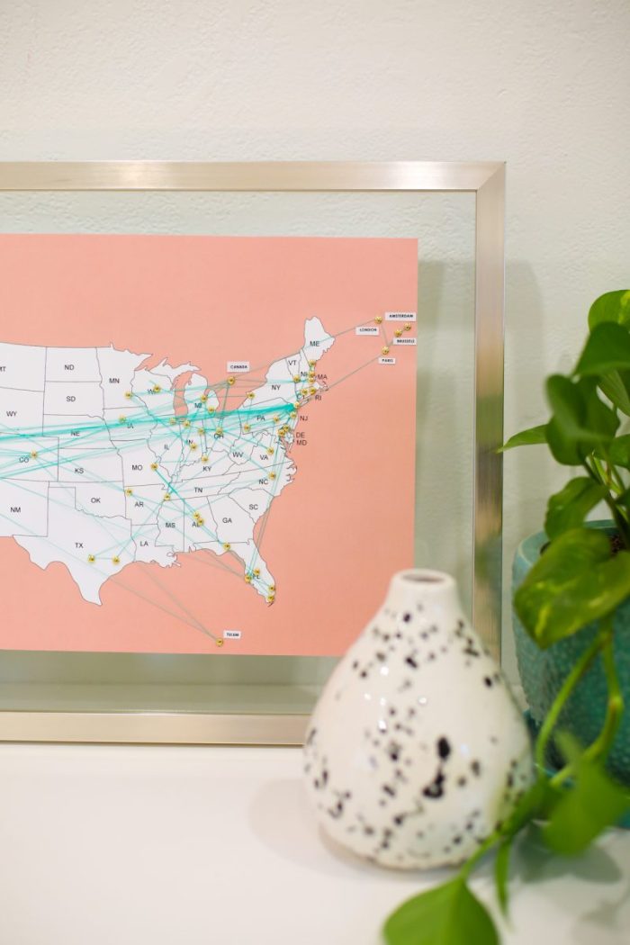 Map of the USA in a frame with pins and yarn on it. 