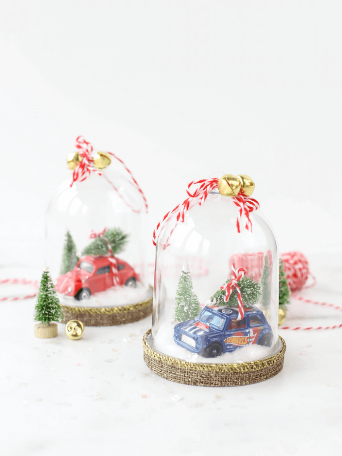 Two snow globe ornaments with hot wheels cars inside. 