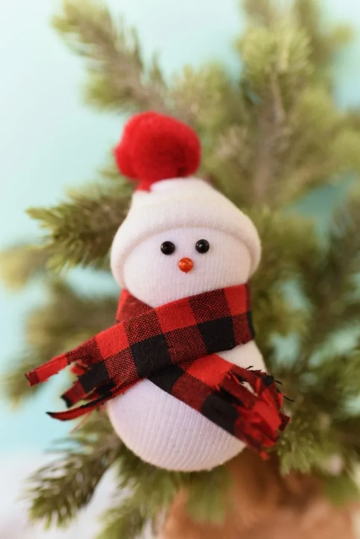 Snowmen ornaments hanging on a tree. 