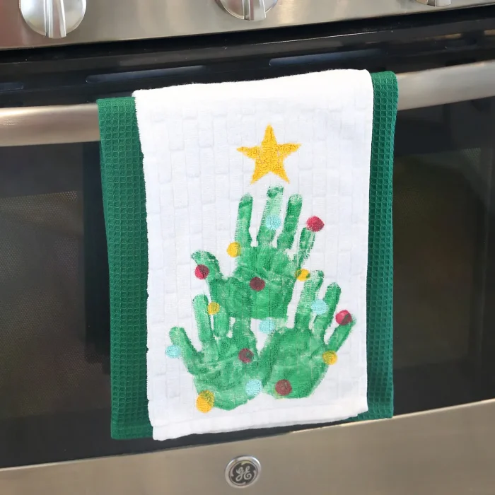 Dish towels with hand prints to make a Christmas tree on it. 