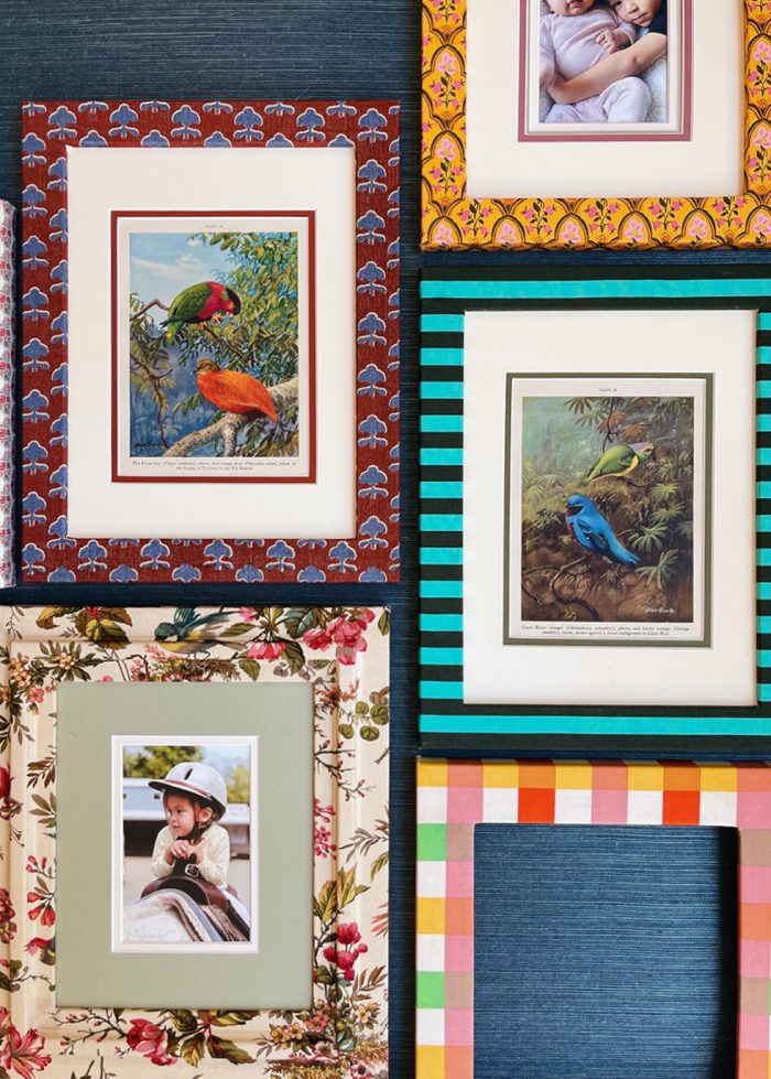 Various embroidered frames on a wall. 