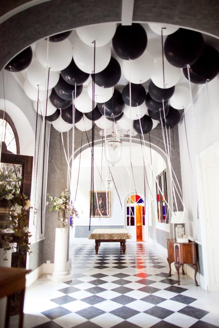 Black and white balloons in a room with a black and white floor. 