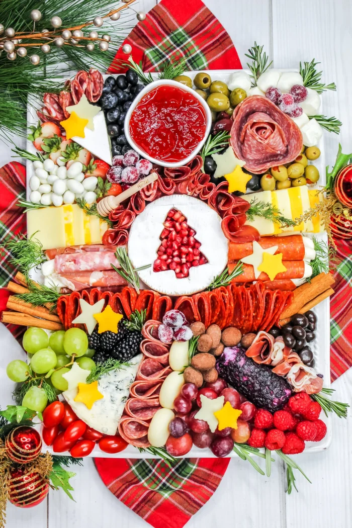 Charcuterie board with cheese stars and brie with a tree cutout. 