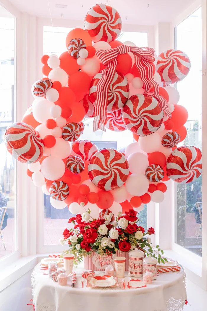 Peppermint balloons with red and white balloons in a balloon arch.
