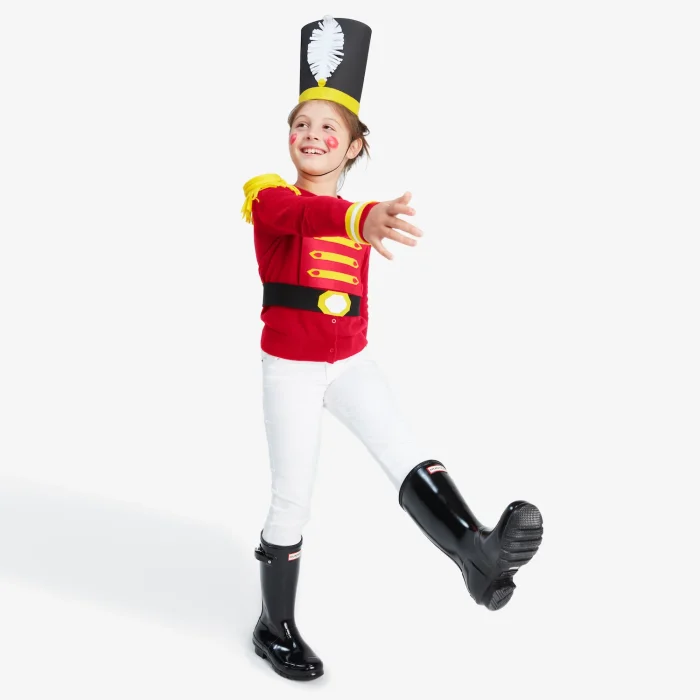 Person standing with one leg up in a walking motion wearing a nutcracker costume. 
