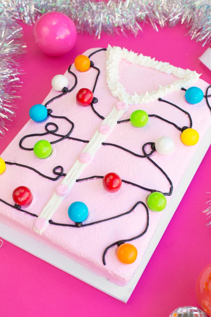 Cake decorated like a pink ugly Christmas sweater. 