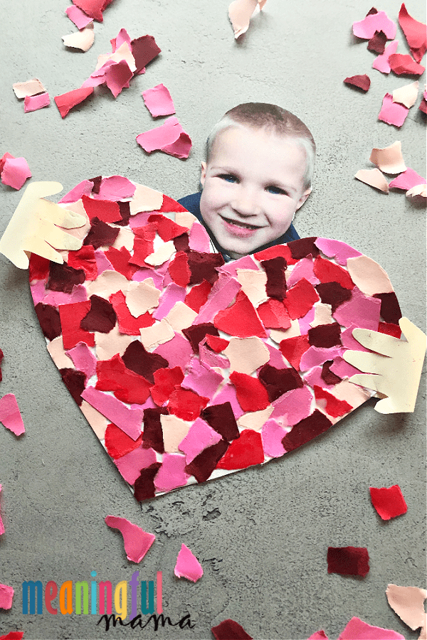 Child's photo with a heart made out of torn up paper. 