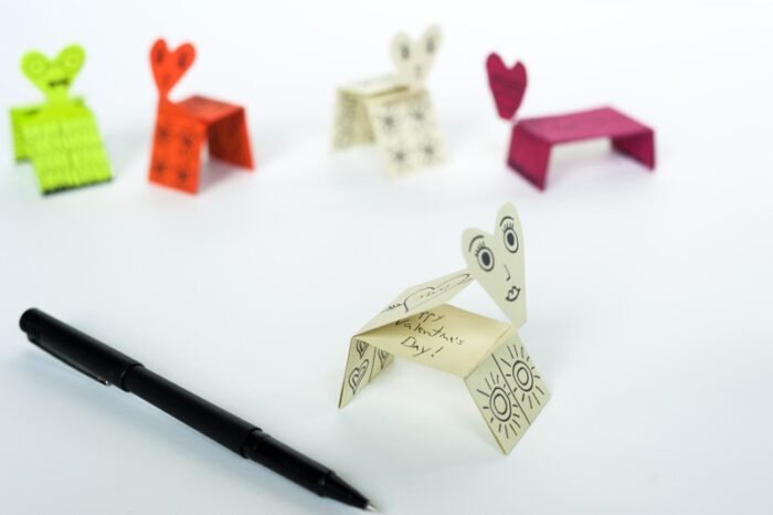 Printable and foldable valentine creatures next to a pen. 