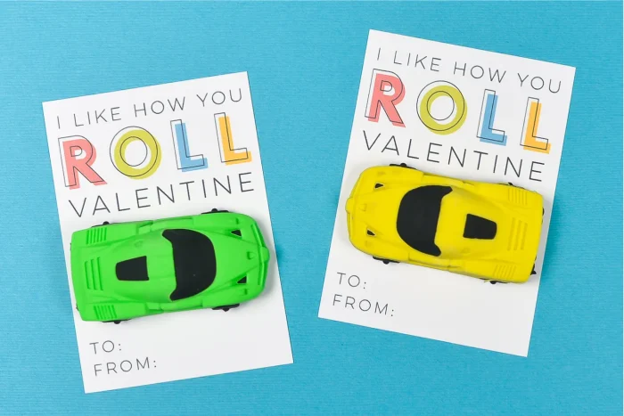 Valentine's messages with toy cars attached on a blue background. 