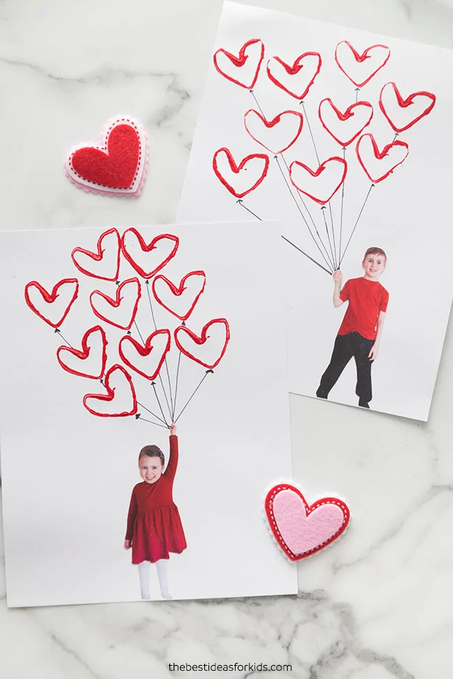 Two pieces of paper each with a photo of a child holding heart-shaped balloons. 