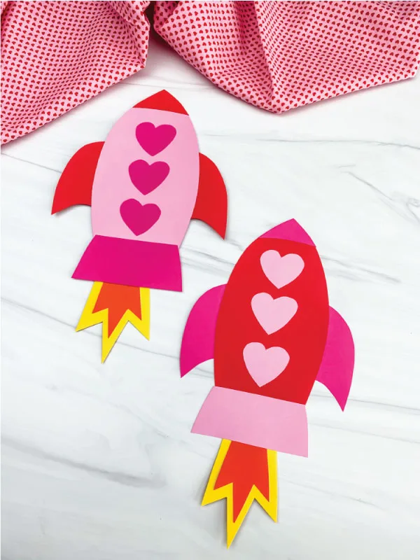 Two paper rockets with hearts as windows. 
