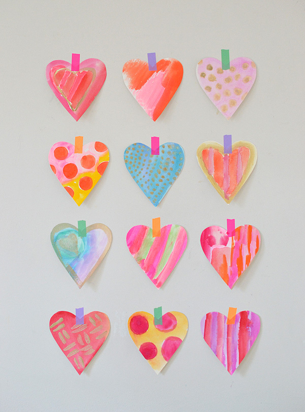 Four rows of colorful watercolor hearts taped to the wall. 