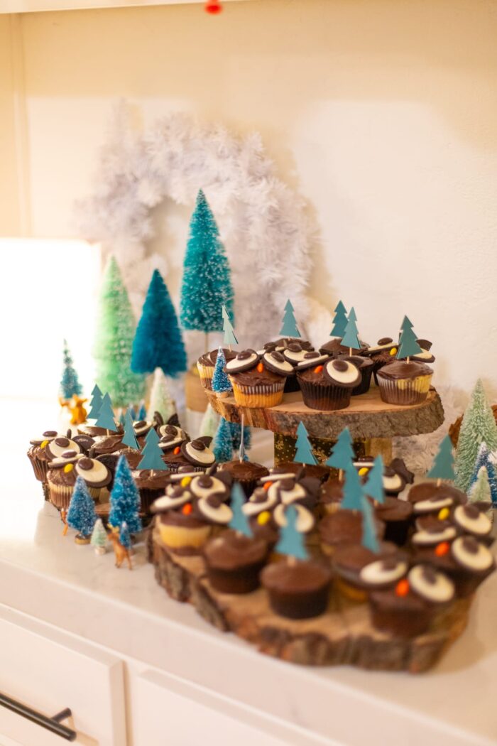 Table set with owl cupcakes and mini trees. 